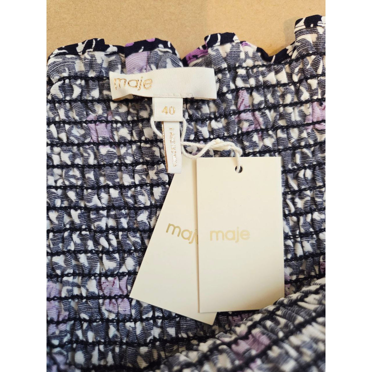 Brand label and attached tags of Maje Rappa floral smocked mini dress