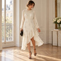 Model wearing an ecru Maje Reto dress with long sleeves and an asymmetric ruffle hem