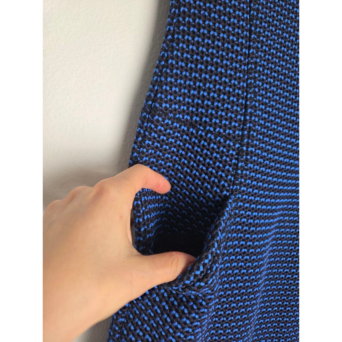 Hand showing side pocket of Derek Lam blue and black sheath dress
