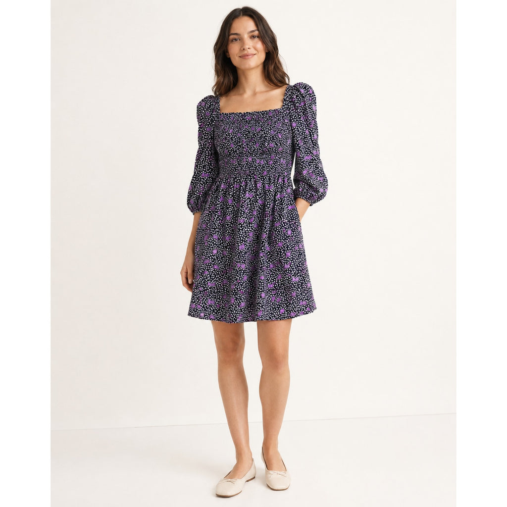 Model wearing a Maje Rappa floral mini dress with a square neckline and smocked bodice