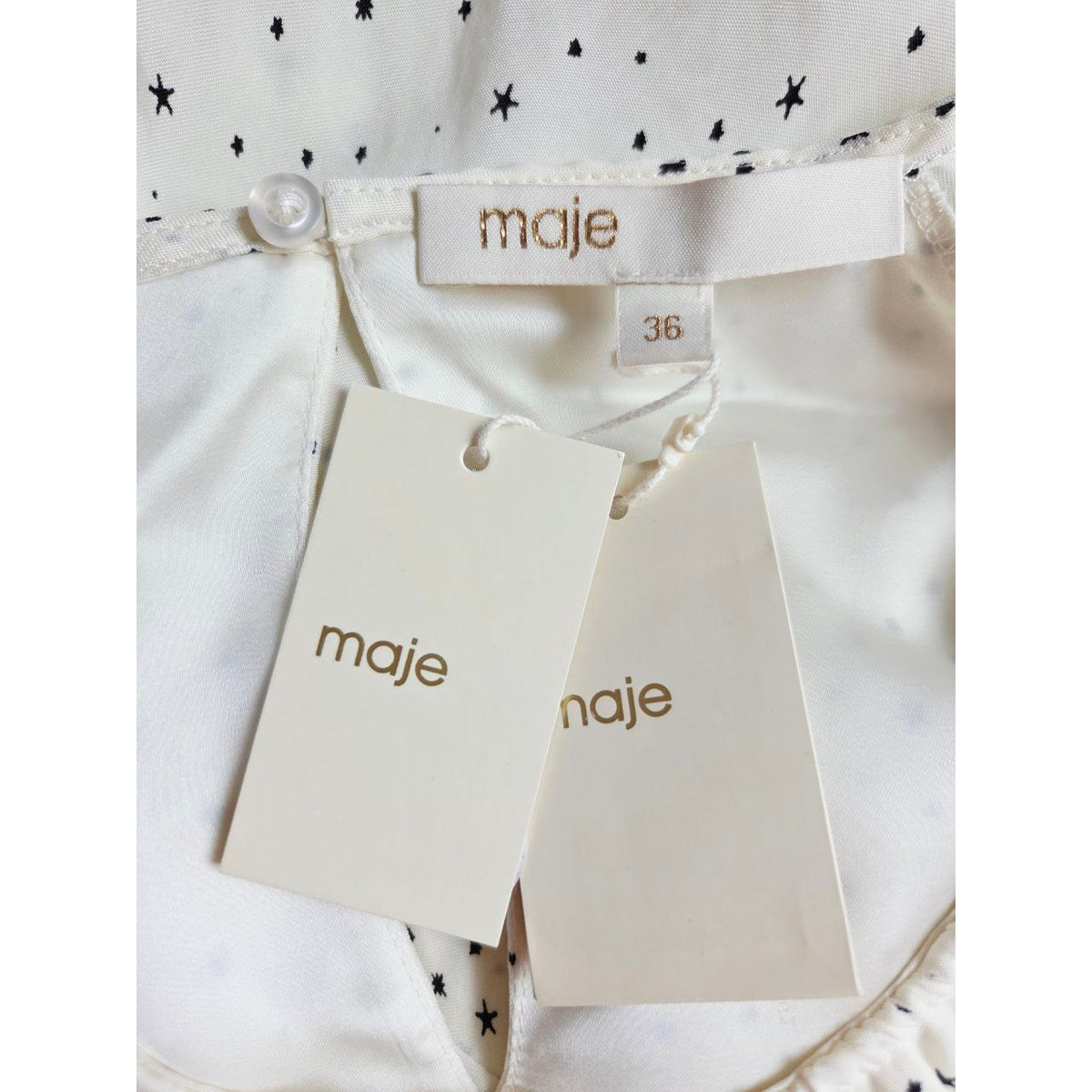 Brand label and attached hangtags of Maje Reto ecru star-print dress