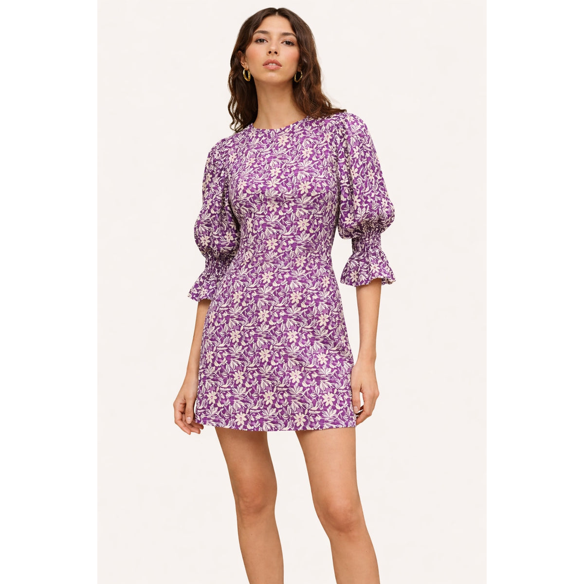 Model wearing a purple and white floral Maje Roniriqua mini dress with three-quarter puff sleeves