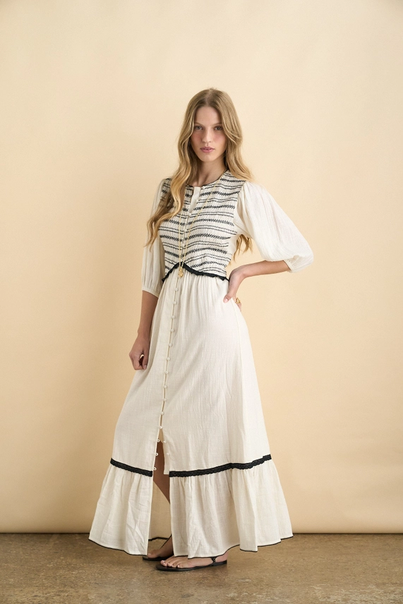Ecru organic cotton maxi dress with puff sleeves and ruffled hem, angled front view