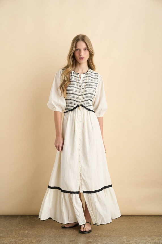 Ecru organic cotton maxi dress with black smocking, puff sleeves and contrast trim, front view